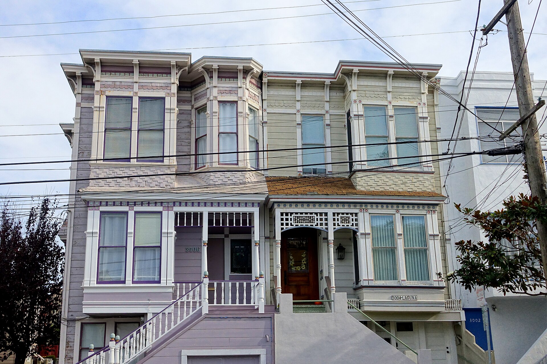 A pair of restored Victorian flats with bay windows and twin entry stairs on Laguna Street in San Francisco.